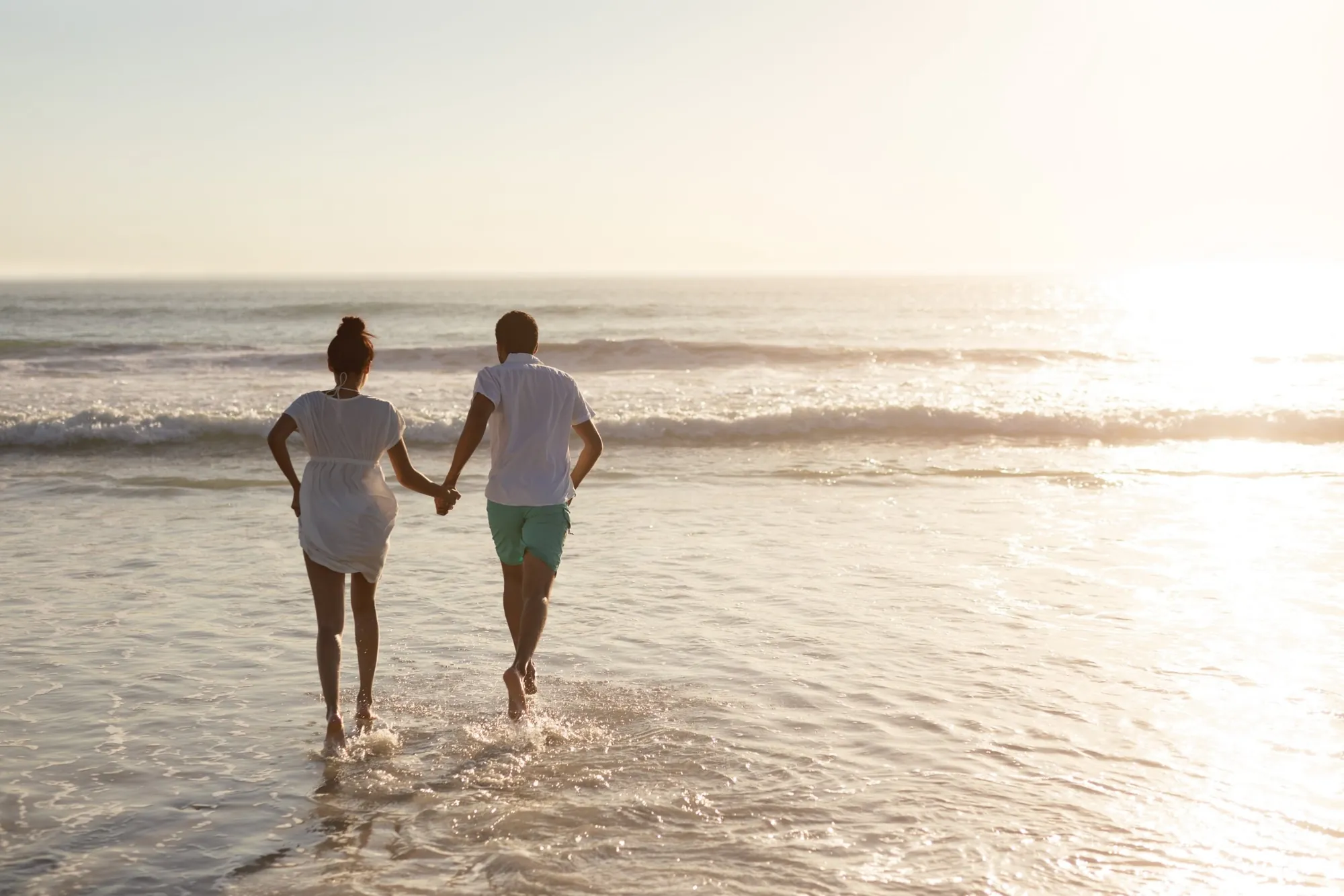 Paar läuft Hand in Hand ins Meer